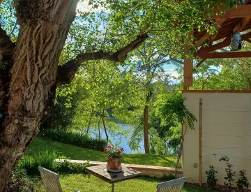 Photo de la terrasse du COULOUMIER Côté Lac sous le peuplier et deux chaises face au lac